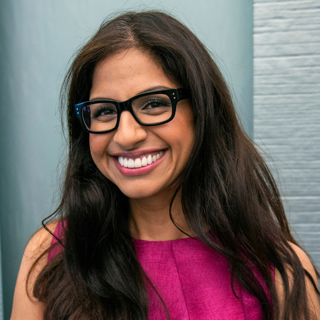 Smiling woman in black glasses and a pink top