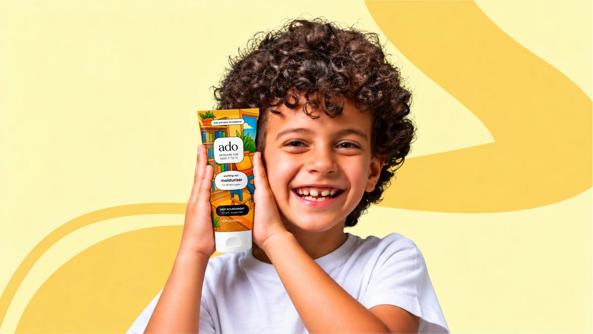 Boy smiling with an ado moisturiser tube on a yellow background