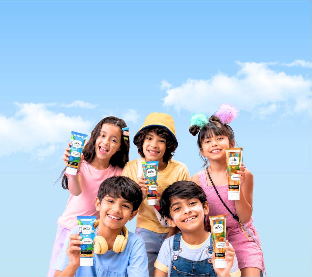 Five smiling kids holding ado skincare tubes against a blue sky