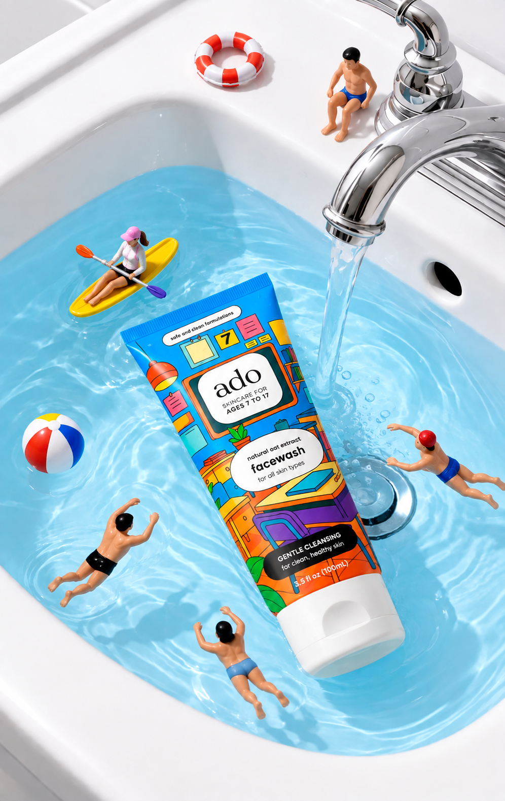 ado Gentle Oat Facewash tube in a sink of running water, with tiny toy swimmers, a kayak and a beach ball