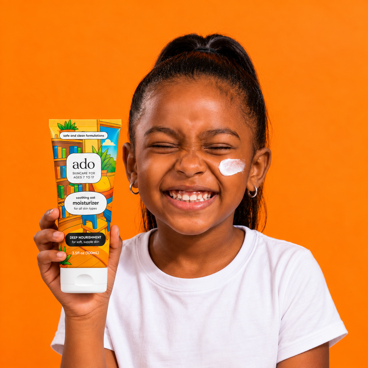 Grinning girl holding the ado Daily Moisturiser tube, with a dab of cream on her cheek, against orange